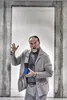 A man is holding stacked cups in front of a concrete doorway. Anteprima dell’immagine prodotto
