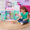 A young girl is playing with a dollhouse in a bedroom. Produktbild-Vorschau
