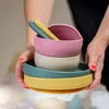 Hands holding a stack of silicone bowls and plates. Náhľad obrázku produktu