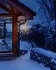 A star-shaped LED light decoration hangs from the eaves of a house in a snowy outdoor setting at dusk. Produktbild-Vorschau