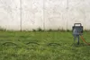 A garden extension cord with multiple outlets and an earth spike is shown in use on grass next to a concrete wall. Anteprima dell’immagine prodotto