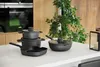 A set of cookware items arranged on a white countertop in a modern kitchen setting. Voir les images du produit