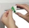 Hands peeling green protective film off a white adhesive bracket for a window blind. Produktbild-Vorschau