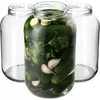 Three empty glass jars and one jar filled with pickles, dill, and garlic. Podgląd zdjęcia produktu