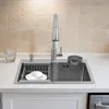 A stainless steel kitchen sink with a faucet, a cup, and a dish rack. Podgląd zdjęcia produktu