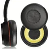 A side view of a black headphone earcup and two replacement earpads, one with a yellow inner cushion. Produktbild-Vorschau