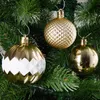 Three gold and white Christmas ornaments hang on a green Christmas tree. Náhľad obrázku produktu
