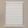 A white roller blind with horizontal stripes is shown covering a window, mounted on a wall. Produktbild-Vorschau