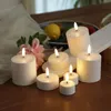 Several LED candles are arranged on a wooden table, with some flowers and fruit in the background. Produktbild-Vorschau