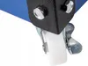 A close-up view of a caster wheel and its locking mechanism attached to a black metal bracket, which is connected to a blue surface. Podgląd zdjęcia produktu