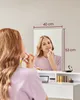 A woman is applying makeup in front of a mirror. Náhled obrázku produktu