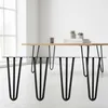 Four black hairpin legs are displayed in the foreground, with a wooden table and a mug on it in the background. Podgląd zdjęcia produktu