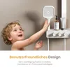 A young child reaching for a shower head in a modern bathroom setting. Podgląd zdjęcia produktu