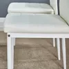 A close-up view of the seat of two white chairs. Produktbild-Vorschau