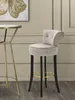A bar stool next to a small table in a room with paneled walls. Podgląd zdjęcia produktu