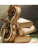 A close-up view of a mechanical wooden cello model with intricate gears, stacked on top of three wooden book models. Náhľad obrázku produktu