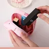 Rosa Reißverschluss-Kosmetiktasche mit Innenfächern, von Händen offen gehalten, mit schwarzem Lippenstift, der hineingelegt wird Náhľad obrázku produktu