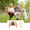 An elderly couple and their dog sitting on a wooden park bench in a grassy park. Voir les images du produit