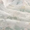 A close-up view of a sheer curtain with a detailed floral pattern. Produktbild-Vorschau