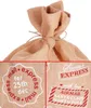 A close-up collage of a burlap Christmas sack with holiday-themed stamps and text. Podgląd zdjęcia produktu