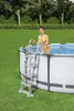 A woman in a yellow bikini is climbing out of an above-ground swimming pool using a ladder. Produktbild-Vorschau
