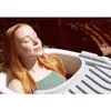A woman relaxing in a bathtub outdoors. Anteprima dell’immagine prodotto