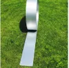 A roll of metal edging is unspooling onto a grassy lawn. Produktbild-Vorschau