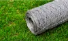 A roll of galvanized steel wire mesh fence lies on green grass. Produktbild-Vorschau