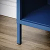 A close-up view of the leg and base of a dark blue metal shelf unit, resting on a wooden floor next to a white baseboard. Anteprima dell’immagine prodotto