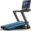 A modern treadmill with a large screen displaying a fitness instructor. Produktbild-Vorschau