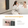 A woman and a baby in a bathroom, with a radiator on the wall. Anteprima dell’immagine prodotto