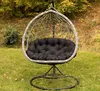 A hanging egg chair with a black cushion sits on a grassy lawn with autumn leaves and trees in the background. Anteprima dell’immagine prodotto