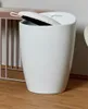 A white bathroom stool and laundry hamper is shown in a room with wooden flooring. Produktbild-Vorschau