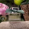 A Chloé perfume bottle is displayed outdoors, surrounded by natural elements like a rose, a lime, and tree bark. Náhled obrázku produktu