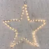 A silver star outline with warm white LED lights against a concrete wall. Produktbild-Vorschau