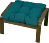 A teal cushion on a wooden ottoman. Produktbild-Vorschau