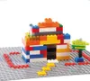 A colorful building block structure resembling a house with a small tree on a gray base plate. Produktbild-Vorschau