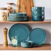A collection of teal-colored stoneware dishes and jars filled with food items are neatly arranged on wooden shelves. Náhled obrázku produktu