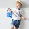 A young boy is holding a blue tablet with a cartoon design and a strap. Produktbild-Vorschau