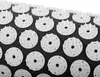 A close-up view of a black acupressure mat with many white circular acupressure points. Podgląd zdjęcia produktu
