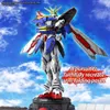 A detailed CG render of a Gundam robot model in a dynamic pose against a cloudy blue sky. Produktbild-Vorschau