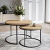 Two round coffee tables of different sizes are placed on a rug in a living room setting. The larger table has a vase with flowers, and the smaller table has a mug. Náhľad obrázku produktu