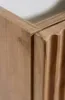 A close-up view of a wooden cabinet corner, showing the texture and carved details of the wood. Náhľad obrázku produktu