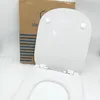 A white toilet seat is shown open, with a cardboard box in the background. Náhled obrázku produktu