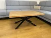 A wooden coffee table with a black metal base is placed in front of a gray sectional sofa in a living room. Anteprima dell’immagine prodotto