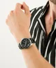 A person wearing a striped shirt and a watch on their wrist. Podgląd zdjęcia produktu