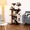 A cat tree with multiple levels and cats on it, placed in a living room setting with a sofa and a lamp. Produktbild-Vorschau