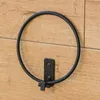 A black metal ring holder mounted on a wooden wall. Náhľad obrázku produktu