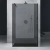 A modern shower enclosure with a walk-in design, featuring a dark gray tinted glass and concrete-like walls. Produktbild-Vorschau