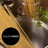 A close-up of spaghetti being prepared, with a pot and herbs in the background. Náhľad obrázku produktu